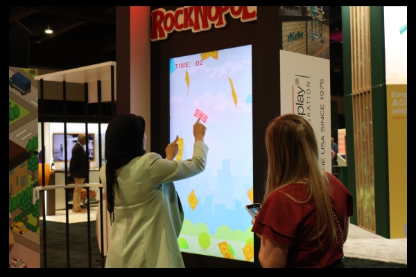 Digital touchscreen game interface at Apple Rock’s ExhibitorLive and EMS exhibits, part of the ROCKNOPOLY experience.