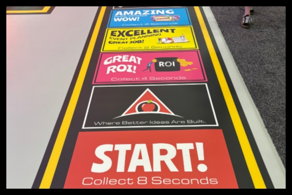 Life-size game board squares leading through Apple Rock’s gamified ExhibitorLive and EMS exhibits.